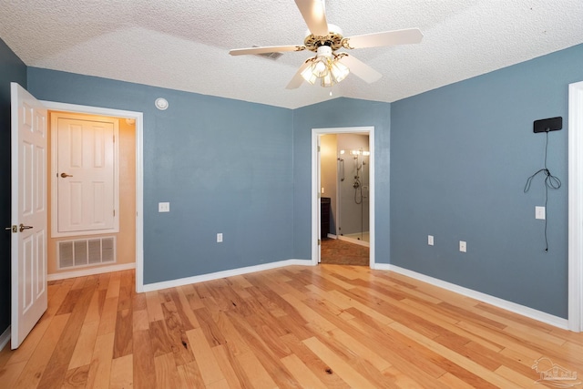 unfurnished bedroom with lofted ceiling, light hardwood / wood-style floors, ceiling fan, and a textured ceiling