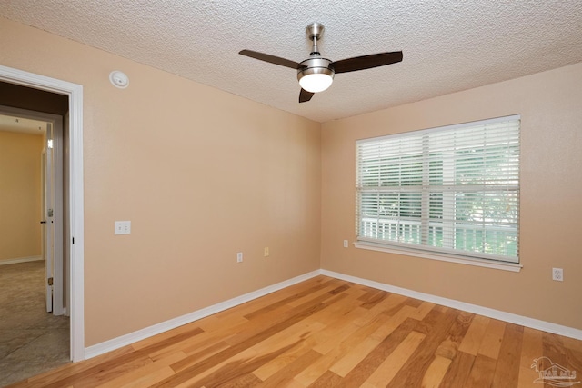 unfurnished room with ceiling fan, a textured ceiling, and hardwood / wood-style floors