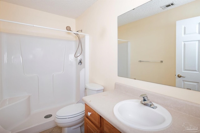 bathroom with walk in shower, a textured ceiling, vanity, and toilet