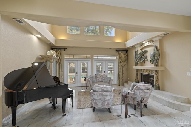 sitting room with visible vents, french doors, tile patterned flooring, and a high end fireplace