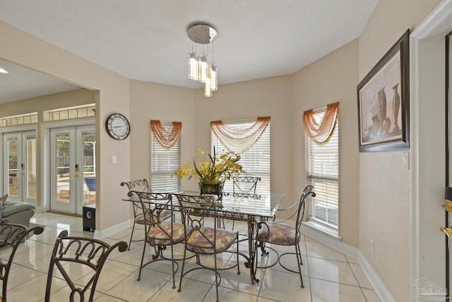 dining room with french doors, light tile patterned flooring, and baseboards