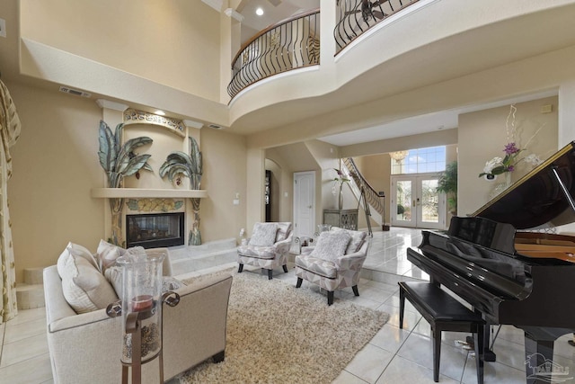 tiled living room featuring visible vents, arched walkways, a high ceiling, french doors, and a fireplace