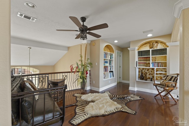 living area featuring lofted ceiling, visible vents, baseboards, and wood finished floors