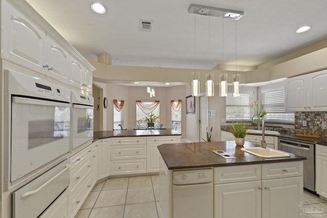 kitchen with a warming drawer, tasteful backsplash, dishwasher, and oven