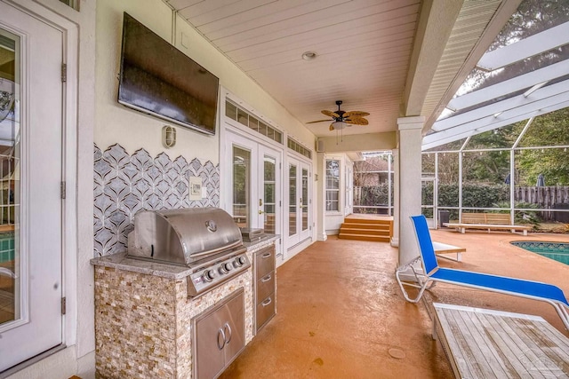 view of patio / terrace with ceiling fan, an outdoor kitchen, a lanai, a grill, and french doors