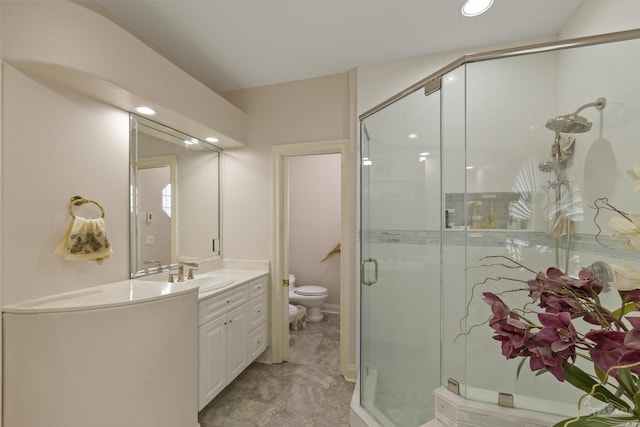 bathroom featuring toilet, a shower stall, and vanity