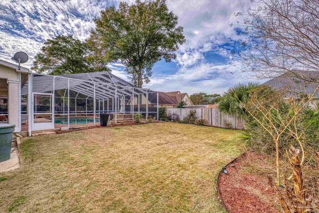 view of yard with glass enclosure, a fenced backyard, and a fenced in pool