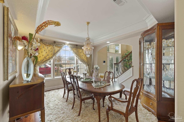 dining space featuring arched walkways, visible vents, baseboards, stairs, and crown molding