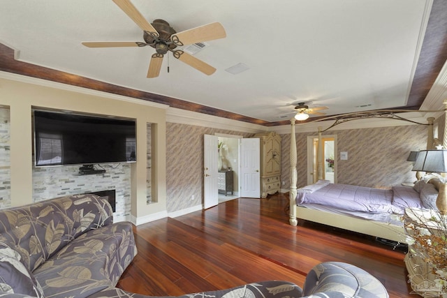 bedroom featuring wallpapered walls, baseboards, wood finished floors, crown molding, and a fireplace