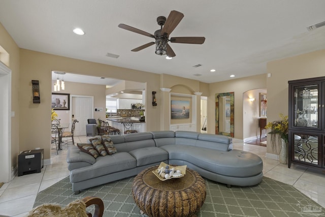 living area with light tile patterned floors, visible vents, arched walkways, ceiling fan, and recessed lighting