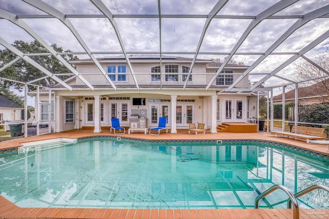 pool with french doors, a patio area, and a lanai