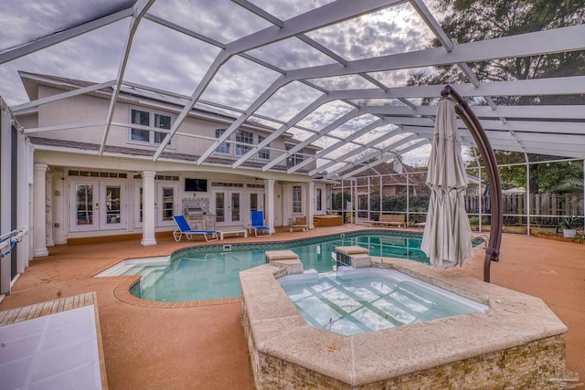 view of swimming pool featuring a lanai, fence, a pool with connected hot tub, french doors, and a patio area