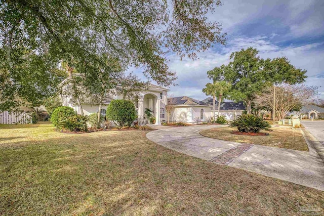 view of front of property with driveway, a front yard, and stucco siding