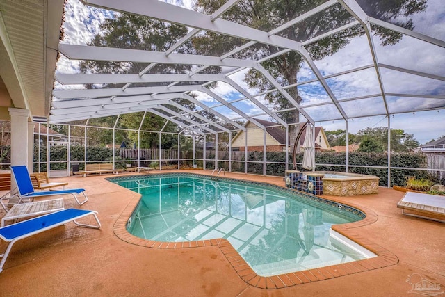 view of swimming pool with a patio, glass enclosure, a fenced backyard, an in ground hot tub, and a fenced in pool