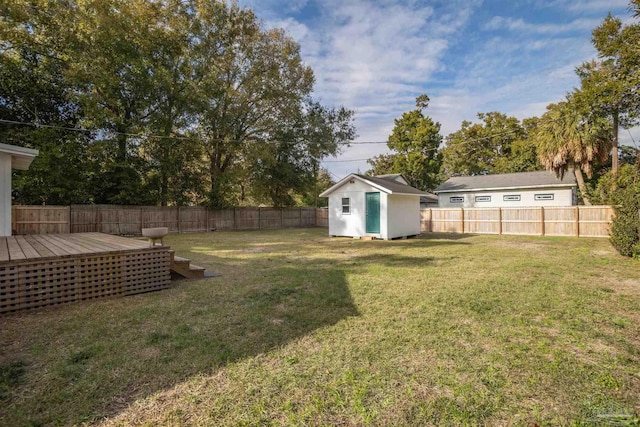 view of yard with a wooden deck and a storage unit