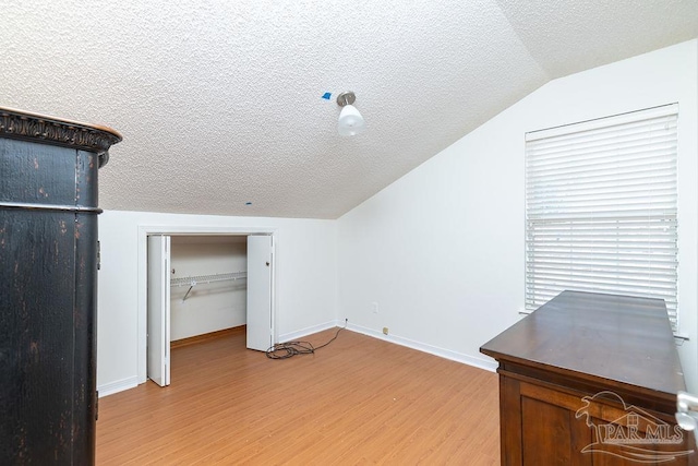 3117 Albert Ct, Pensacola, FL 32504 - additional living space with a textured ceiling, vaulted ceiling, baseboards, and light wood finished floors