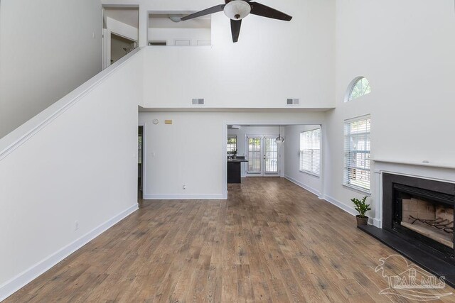 3117 Albert Ct, Pensacola, FL 32504 - unfurnished living room featuring a fireplace with raised hearth, a high ceiling, visible vents, and ceiling fan