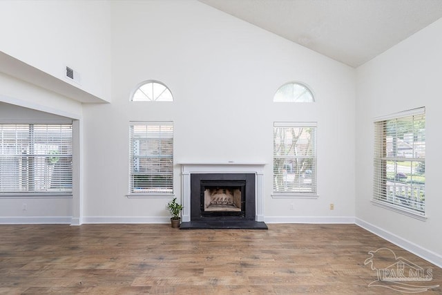 3117 Albert Ct, Pensacola, FL 32504 - unfurnished living room featuring a fireplace with raised hearth, high vaulted ceiling, visible vents, and plenty of natural light