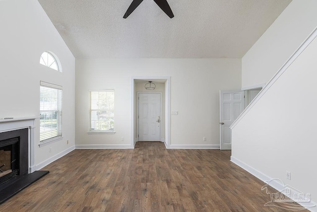 3117 Albert Ct, Pensacola, FL 32504 - unfurnished living room with a fireplace with raised hearth, a textured ceiling, a ceiling fan, baseboards, and wood finished floors