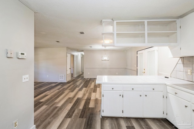 kitchen featuring tile counters, white cabinets, and dark hardwood / wood-style floors