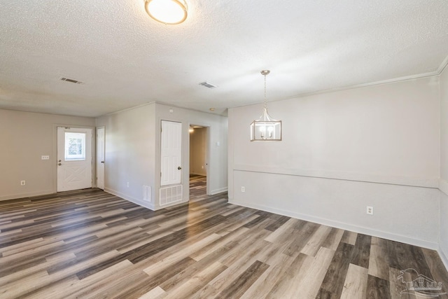 unfurnished room with hardwood / wood-style floors and a textured ceiling