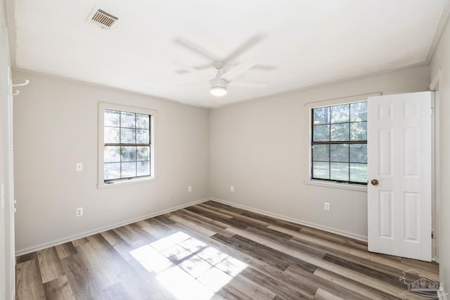 empty room featuring hardwood / wood-style floors, plenty of natural light, ceiling fan, and crown molding