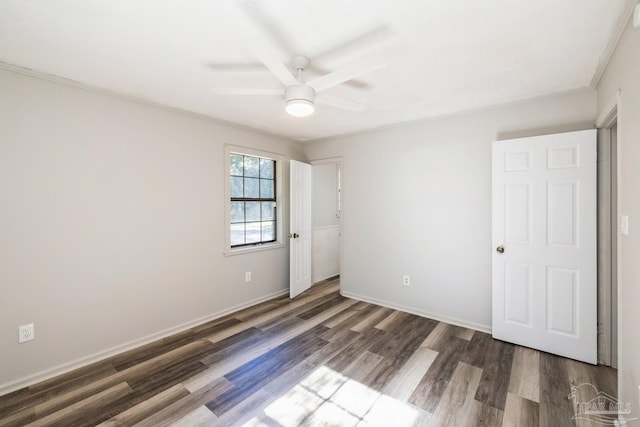 unfurnished bedroom featuring dark hardwood / wood-style floors, ceiling fan, and crown molding