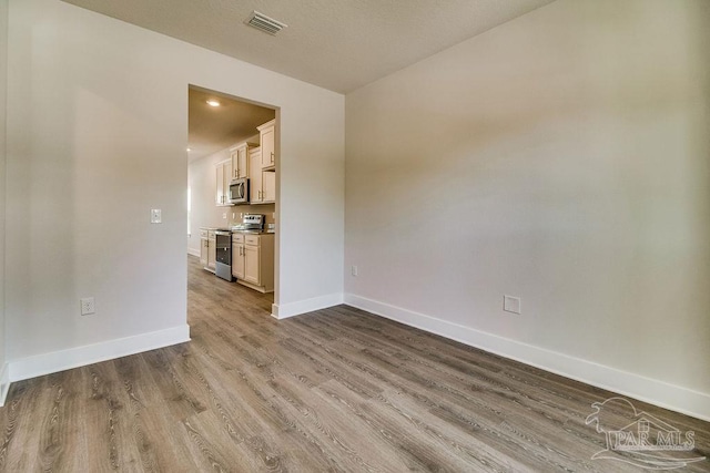 spare room with hardwood / wood-style floors