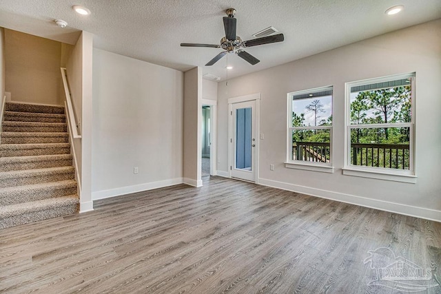 unfurnished living room featuring hardwood / wood-style floors, a textured ceiling, and ceiling fan