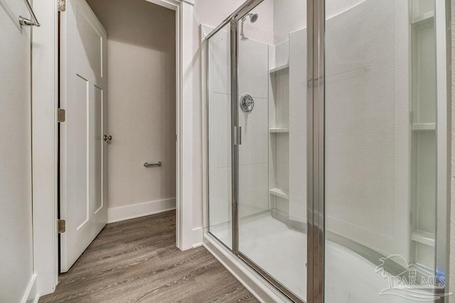 bathroom with hardwood / wood-style floors and a shower with door