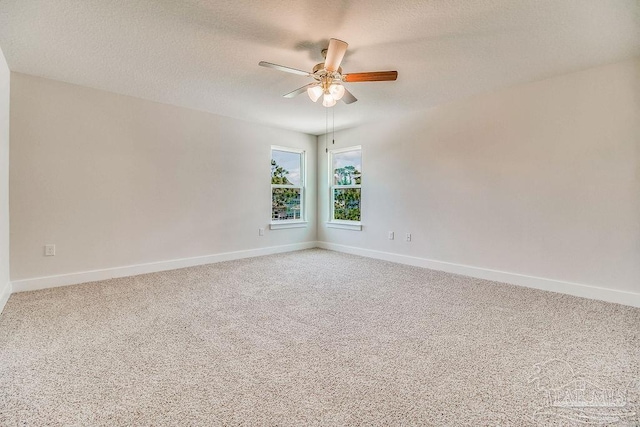 empty room featuring ceiling fan, carpet floors, and a textured ceiling