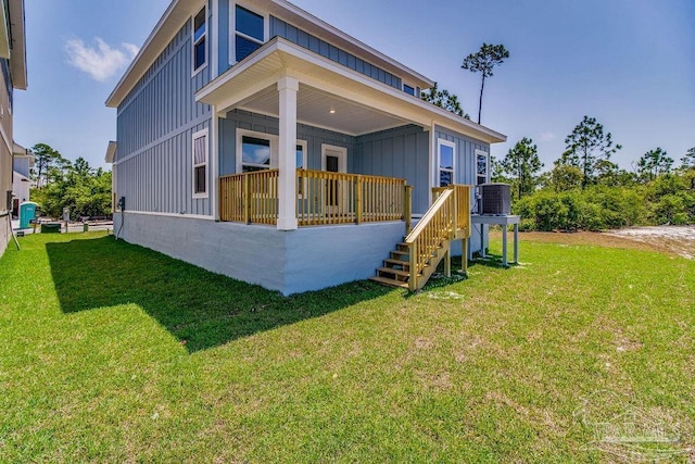 rear view of house featuring a lawn and central AC unit