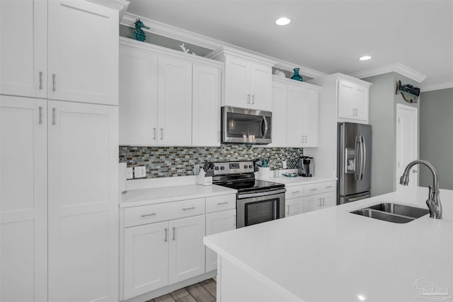 kitchen with a sink, stainless steel appliances, tasteful backsplash, light countertops, and ornamental molding