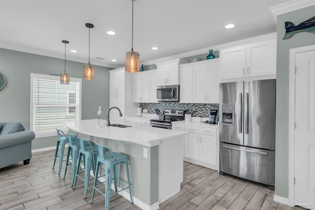 kitchen with a kitchen breakfast bar, stainless steel appliances, wood finish floors, and a sink