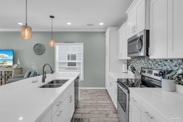 kitchen featuring stainless steel appliances, backsplash, light countertops, and a sink