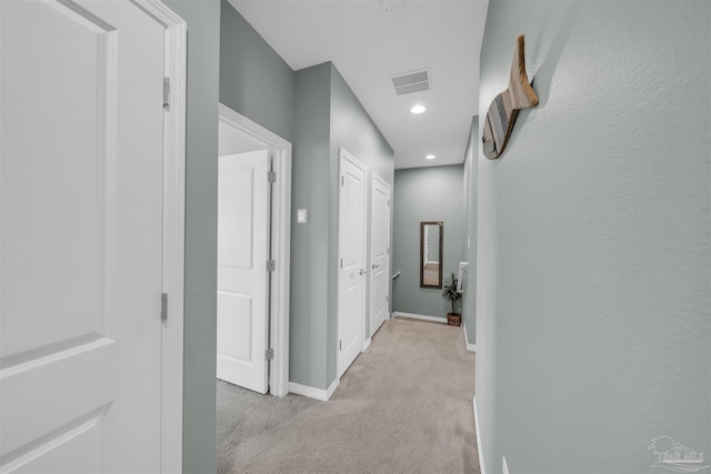 hall featuring recessed lighting, visible vents, light carpet, and baseboards