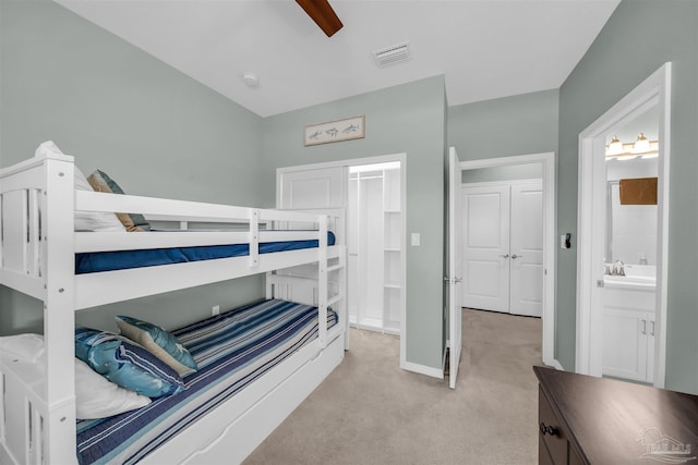 bedroom with light carpet, a sink, baseboards, visible vents, and a ceiling fan