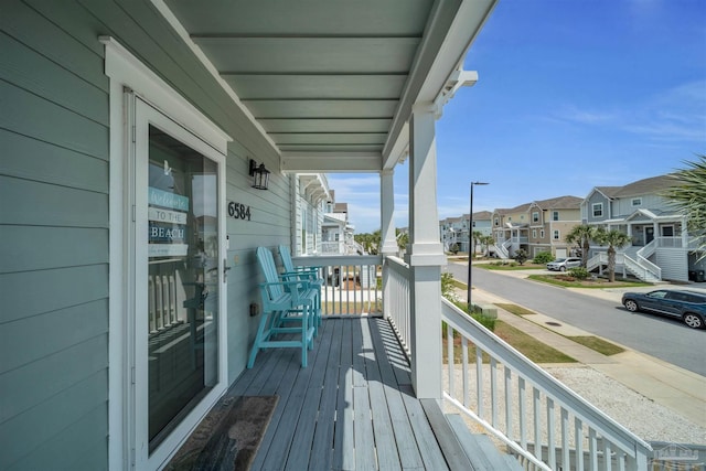 wooden deck featuring a porch and a residential view