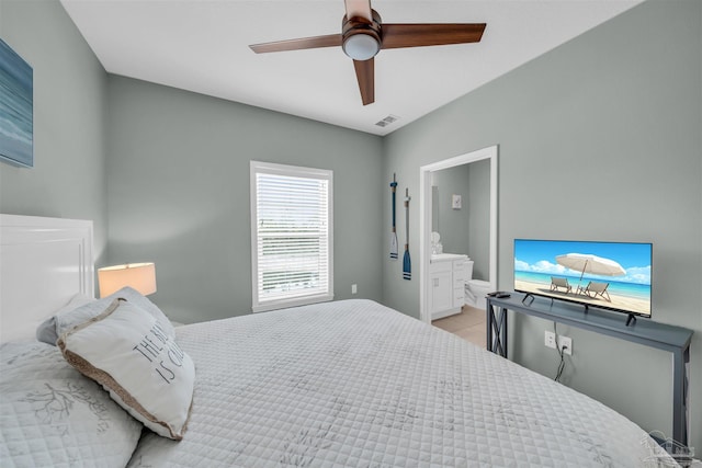 bedroom with visible vents, light tile patterned floors, a ceiling fan, and ensuite bathroom