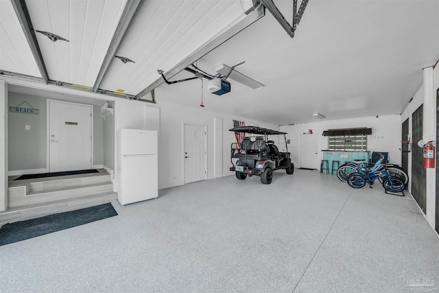 garage with a garage door opener and freestanding refrigerator