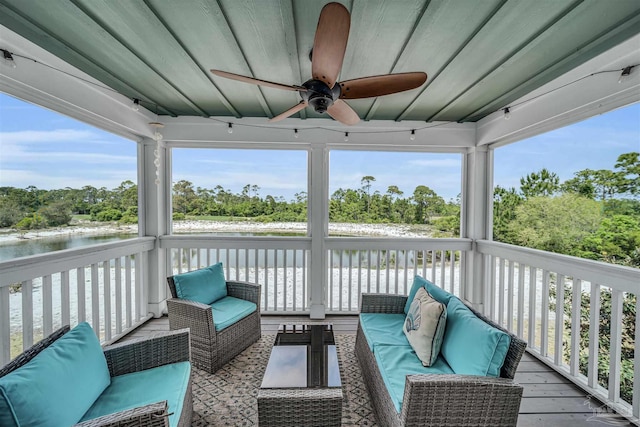 sunroom / solarium featuring a ceiling fan, a water view, and an outdoor hangout area