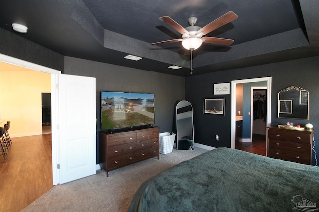 bedroom featuring carpet floors, a tray ceiling, and ceiling fan