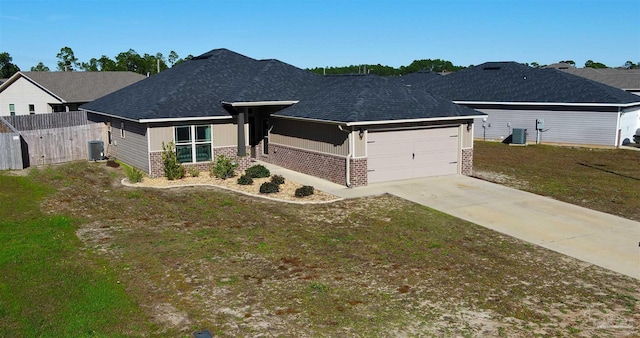 view of front of home featuring central AC unit, a garage, and a front lawn