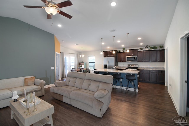 living room with dark hardwood / wood-style flooring, ceiling fan, sink, and vaulted ceiling