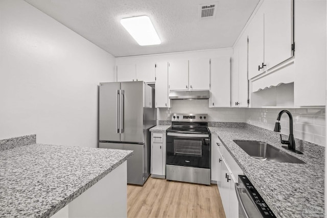 kitchen with white cabinets, light wood-type flooring, stainless steel appliances, and sink