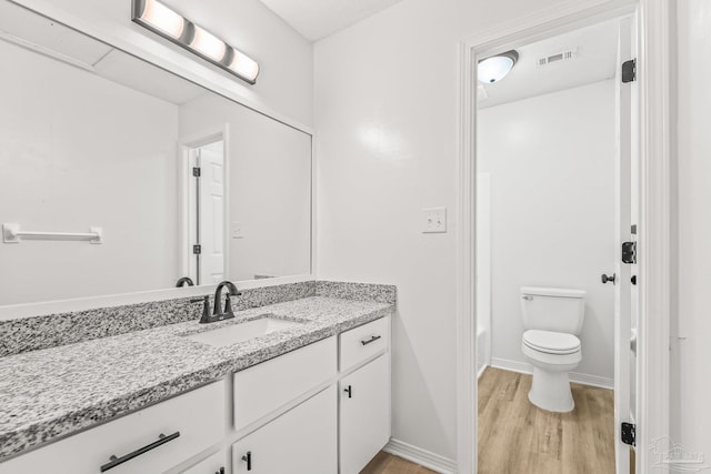 bathroom with hardwood / wood-style floors, vanity, and toilet