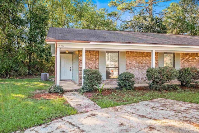 ranch-style house featuring central AC, a front lawn, and covered porch