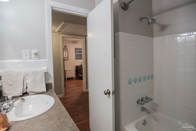 bathroom featuring wood-type flooring, vanity, and shower / tub combination