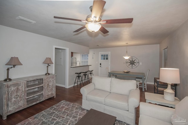 living room with dark hardwood / wood-style flooring, ceiling fan, and sink