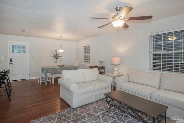 living room with ceiling fan and dark hardwood / wood-style flooring